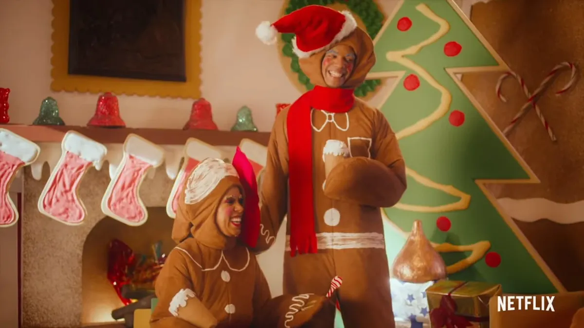 Two actors dressed as gingerbread men wear giant smiles.