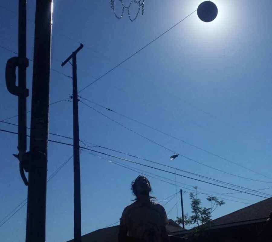 a basketball perfectly placed over the sun