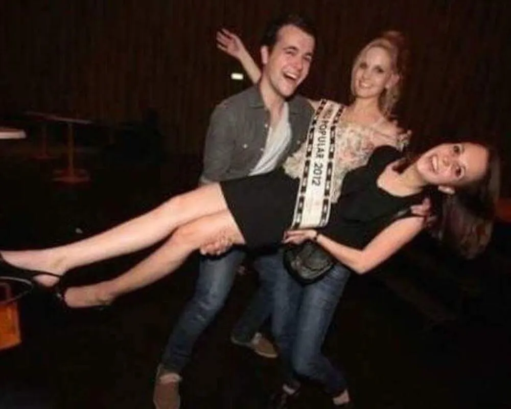 girl and guy holding up winner wearing sash