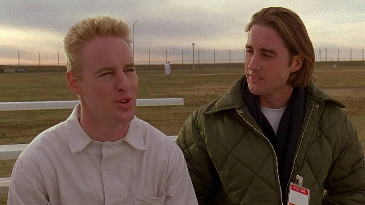 owen and luke wilson in front of a grass field